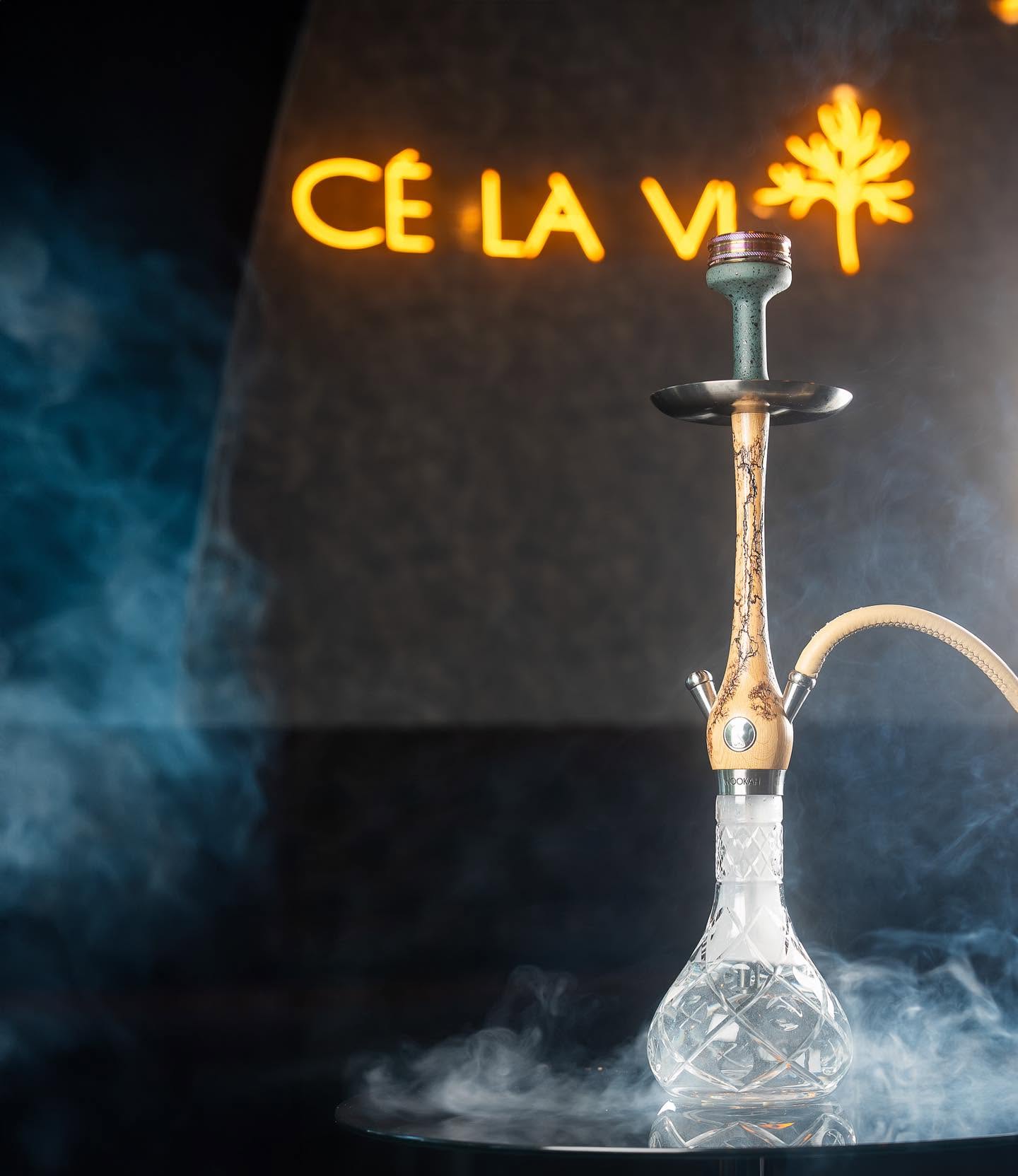 Premium Shisha vor leuchtendem CÉ LA VI Logo